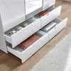 Close-up view of open drawers in a white wardrobe, showing folded clothes and a box. Produktbild-Vorschau