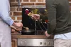 Two people are cooking in a kitchen, with one person adding spices to a pan. Náhľad obrázku produktu