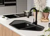 A modern kitchen sink and faucet setup on a countertop, with decorative plants and a pot on a stovetop in the background. Produktbild-Vorschau