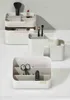 Several white cosmetic organizers are arranged on a light gray surface. Náhled obrázku produktu