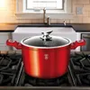 A red pot with a glass lid sits on a gas stove in a kitchen. Voir les images du produit