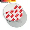 A close-up view of two round metal discs, one with a peel-back adhesive backing covered in red and white 3M logos, and a smaller silver disc on the bottom. Anteprima dell’immagine prodotto