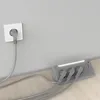 A power strip with multiple outlets and USB ports is plugged into a wall socket. The power strip is on a wooden floor next to a wall. Produktbild-Vorschau