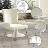 A cream-colored dining chair with gold legs is shown in a room with a large window. Anteprima dell’immagine prodotto