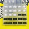 A clear plastic box containing spools of thread, mostly white and some black, is placed on a yellow and white patterned surface. Produktbild-Vorschau