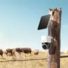 A solar-powered security camera mounted on a wooden post in a field with cows in the background. Náhľad obrázku produktu