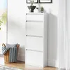 A white shoe cabinet with four flip-down drawers stands against a white wall, next to a window with sheer curtains. A woven basket filled with a pillow and blankets is placed to the left of the cabinet. Náhľad obrázku produktu