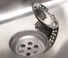 A close-up view of a stainless steel sink drain with a strainer basket. Produktbild-Vorschau