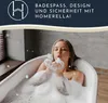 A woman blowing bubbles in a bathtub. Produktbild-Vorschau