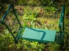 A green garden kneeler and seat is placed on the grass in a garden setting. Produktbild-Vorschau