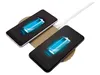 Two smartphones are wirelessly charging on a gold-colored charging pad, connected to a white cable. Produktbild-Vorschau