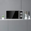 A microwave oven is placed on a shelf in a modern kitchen setting. Produktbild-Vorschau