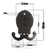 A black metal double hook with measurement lines and labels overlaid. Produktbild-Vorschau