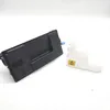 A black toner cartridge and a white liquid container are placed on a white surface. Produktbild-Vorschau