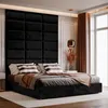 A bedroom scene with a large upholstered headboard and a bed made with dark linens and accent pillows. Anteprima dell’immagine prodotto