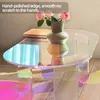 A close-up of an iridescent acrylic coffee table with a vase of pink roses on top. Anteprima dell’immagine prodotto