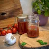 A still life arrangement of ingredients and jars, suggesting homemade food preservation. Produktbild-Vorschau