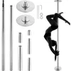 A woman performing a pole dance pose on a silver pole, with various pole dance accessories laid out around it. Náhľad obrázku produktu