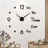 A large, modern wall clock with 3D numbers and hands is mounted on a white wall. Produktbild-Vorschau