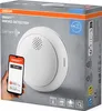 The image shows the packaging of an OSRAM SMART+ Smoke Detector, with a smartphone displaying the SMART+ app. Produktbild-Vorschau