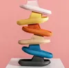 Stapel von sechs bunten Schlapfen: pink, gelb, orange, beige, blau und schwarz, auf pinkem Hintergrund Anteprima dell’immagine prodotto