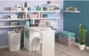 A room with shelves filled with storage boxes, a desk, and a plant. Náhľad obrázku produktu