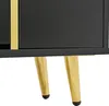 A close-up view of the bottom section of a black cabinet with gold accents and legs. Anteprima dell’immagine prodotto
