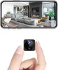 A hand holding a mini camera with a living room scene displayed on a phone screen above. Produktbild-Vorschau