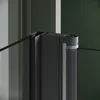 A close-up view of a shower enclosure corner with a black frame and glass panels. Podgląd zdjęcia produktu