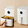 A split image showing a white air fryer. The left side shows the drawer pulled out with food inside and a hand reaching for the handle. The right side shows the air fryer closed. Podgląd zdjęcia produktu