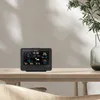 A digital weather station is displayed on a wooden table, with a plant in a vase in the background. Produktbild-Vorschau