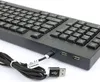 A close-up view of a black keyboard with a USB cable plugged into its side. Podgląd zdjęcia produktu