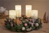 A Christmas advent wreath with four LED candles and festive decorations on a wooden table. Produktbild-Vorschau