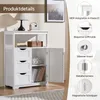 A white wooden cabinet with drawers and a door, shown in a room setting with a lamp and artwork in the background. Callouts highlight product features. Produktbild-Vorschau