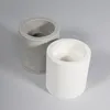 Two cylindrical candle holders, one gray and one white, are placed on a light gray surface. Podgląd zdjęcia produktu