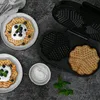 A waffle maker with waffles and toppings on a dark textured surface. Podgląd zdjęcia produktu