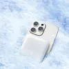 A white power bank is attached to the back of a silver smartphone, both partially submerged in snow. Podgląd zdjęcia produktu