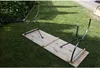 A wooden bench with metal legs is laid out on a grassy lawn. Náhled obrázku produktu