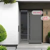 A modern gray front door with a glass panel and a long handle, set against a white wall and wooden slats. Dimensions are indicated with text overlays. Produktbild-Vorschau