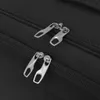 A close-up view of two zippers on a black fabric item. Voir les images du produit