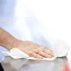 A hand wiping a surface with a white paper towel. Produktbild-Vorschau