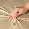 A hand touching a beige fabric, likely a bedsheet, with a graphic overlay indicating 'Ultra sanfter Touch' and 'Ultra soft touch'. Produktbild-Vorschau