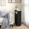 A black narrow cabinet with drawers and baskets is placed next to a sofa in a living room. Náhled obrázku produktu