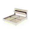A white bed frame with a wooden slatted base and a beige headboard with integrated LED lighting. Produktbild-Vorschau