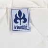 A close-up of a white quilted fabric with a blue and white label attached. Produktbild-Vorschau