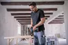 A man is using a cordless drill to drill into a wooden beam in a room under renovation. Náhled obrázku produktu