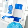 A manual water dispenser pump attached to a large water bottle, with other water bottles in the background. Produktbild-Vorschau