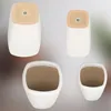 Four white ceramic planters with tan interiors are displayed against a light gray background. Two planters are shown from the top, and two are shown from the side. Náhľad obrázku produktu