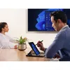 A man and a woman in an office setting, with a large screen displaying Windows 11 in the background. The man is using a tablet with a stylus. Produktbild-Vorschau