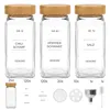 A collection of glass spice jars with bamboo lids and various accessories, laid out on a white background. Produktbild-Vorschau